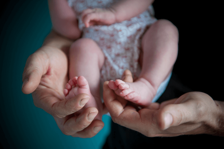 Man holding baby's feet
